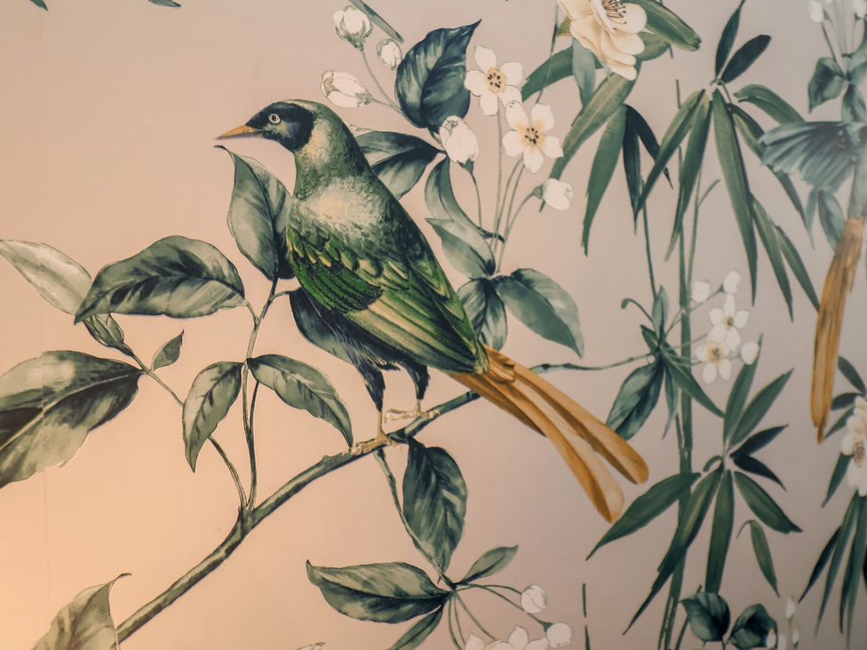 A bird perched on a branch surrounded by leaves and flowers