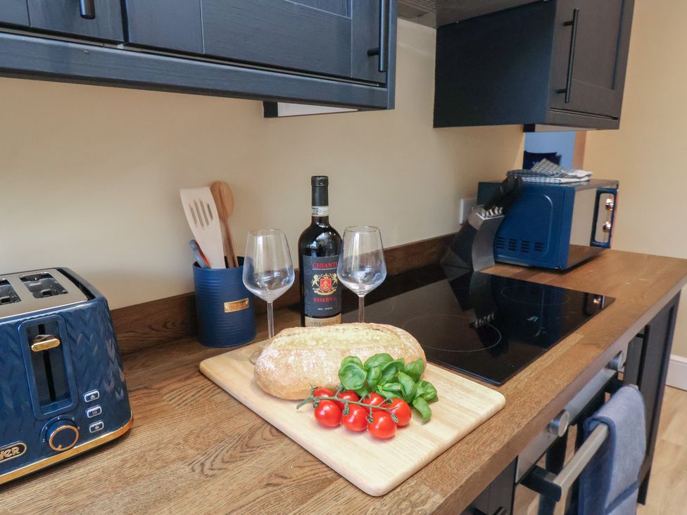 A kitchen with a cutting board and wine setup at Apartment 2, Blackburn Heights in Bridlington