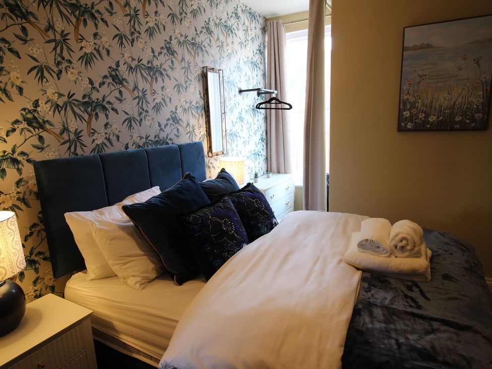 A bedroom with a bed and decorative items at Blackburn Heights Apartment in Bridlington