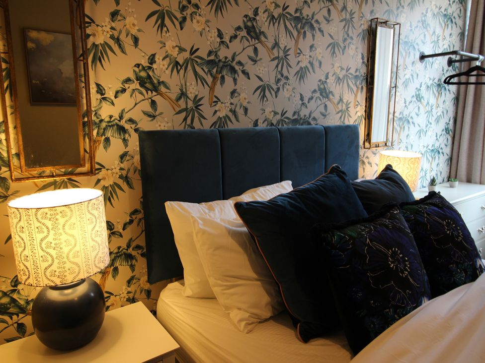 A bedroom with a bed and lamps at Blackburn Heights Apartment in Bridlington