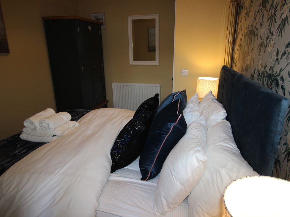 A bedroom with a bed and wardrobe at Blackburn Heights Apartment in Bridlington