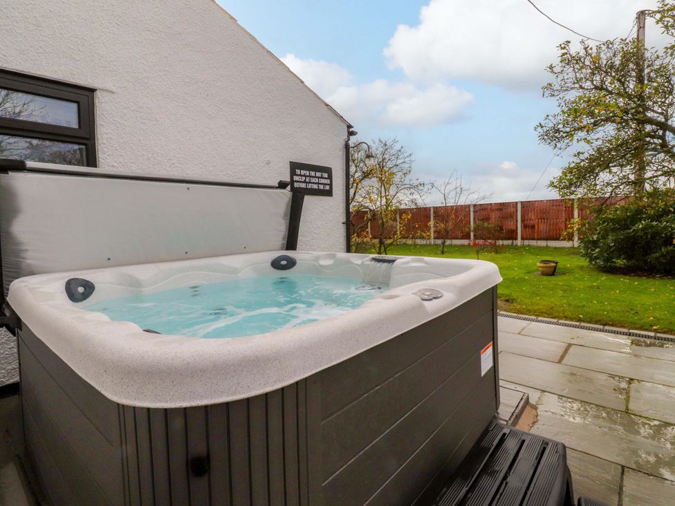 A hot tub on a patio in the garden at Brook House, Broughton, Lancashire