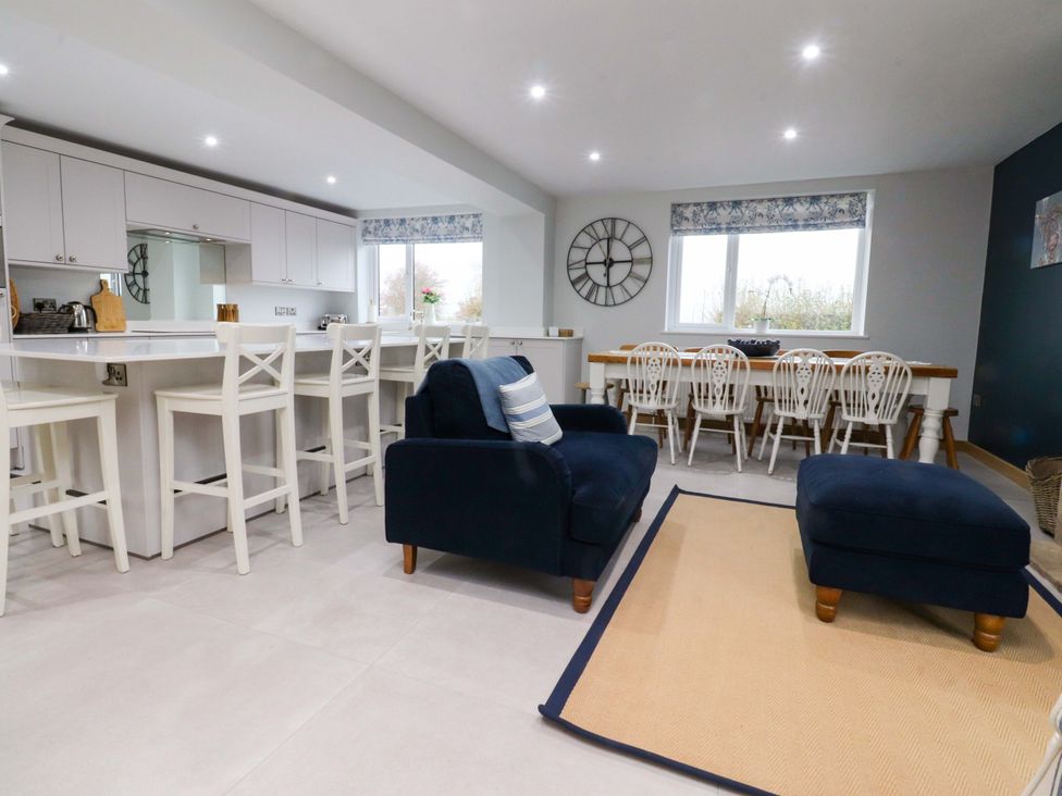 A kitchen with bar stools and a dining table at Brook House in Broughton, Lancashire