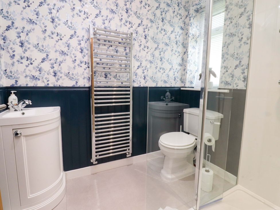 A bathroom with a sink, toilet, and towel radiator at Brook House in Broughton, Lancashire
