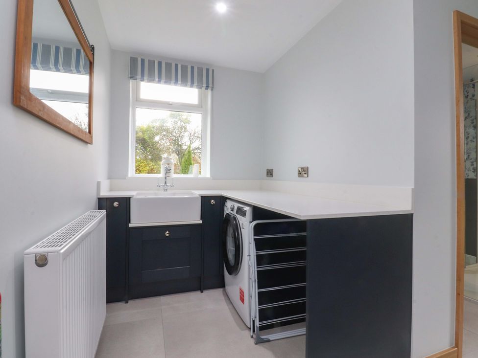 A laundry room with a sink and washing machine at Brook House Broughton, Lancashire