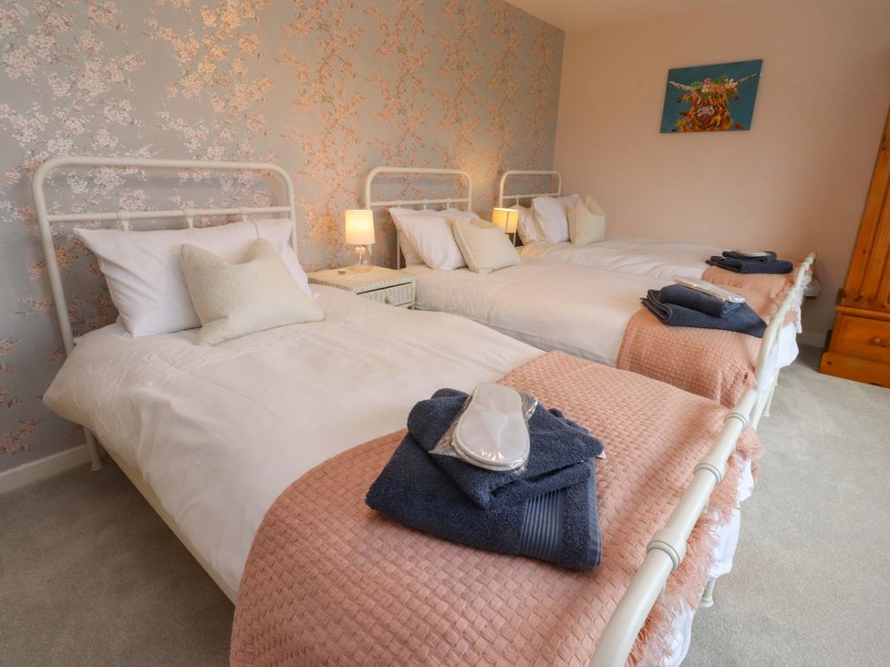 A bedroom with three beds and a wardrobe at Brook House in Broughton, Lancashire