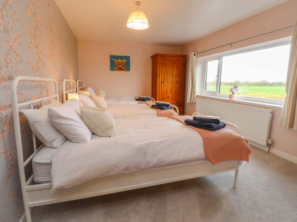 A bedroom with two beds and a wardrobe at Brook House in Broughton, Lancashire
