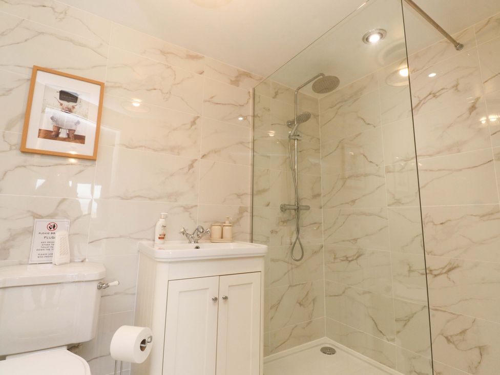 A bathroom with a shower, toilet, and sink at Brook House Broughton, Lancashire