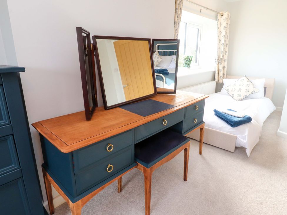 A bedroom with a dressing table and bed at Brook House, Broughton, Lancashire