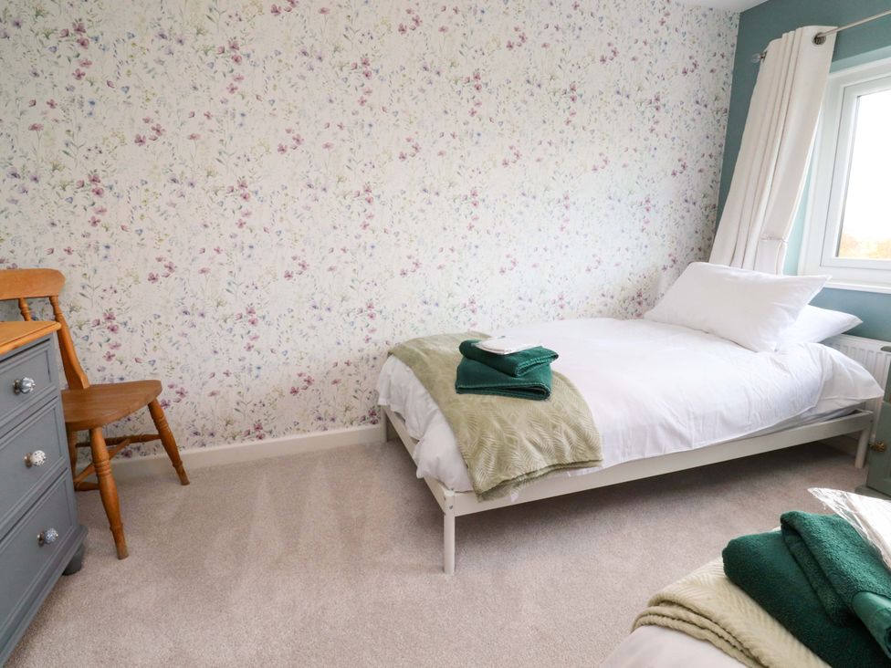 A bedroom with a bed and a chair at Brook House in Broughton, Lancashire