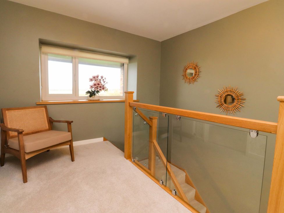 A landing with a chair and window at Brook House in Broughton, Lancashire