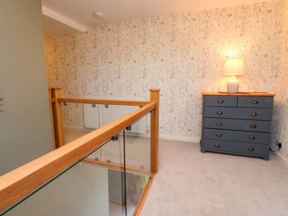A hallway with a dresser and lamp at Brook House in Broughton Lancashire