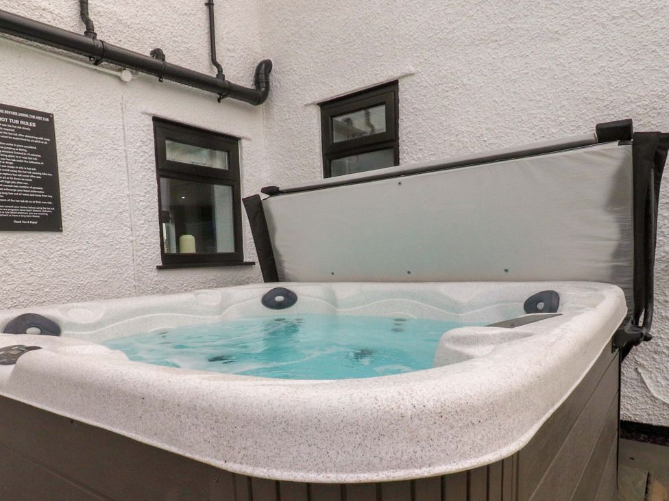 A hot tub with water in a courtyard at Brook House in Broughton, Lancashire