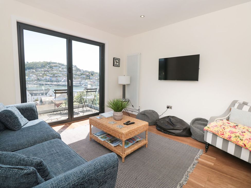 A living room with a television and a view at Ty'r Ddraig in Dartmouth