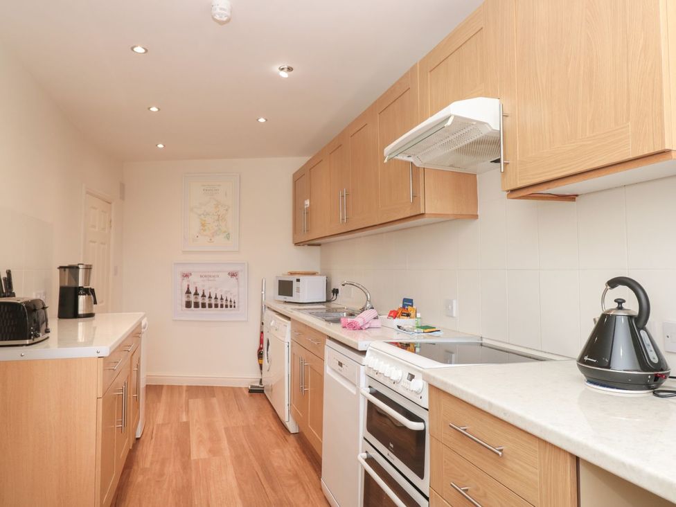 A kitchen with appliances and cabinets at Ty'r Ddraig Dartmouth