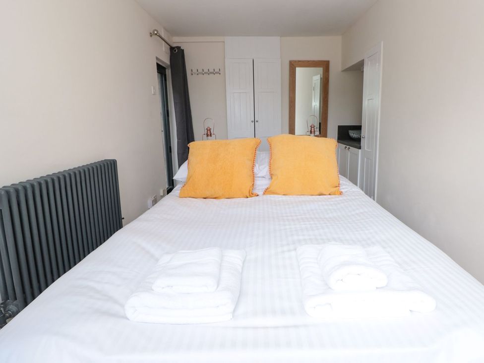 A bedroom with a bed and towels at Ty'r Ddraig in Dartmouth