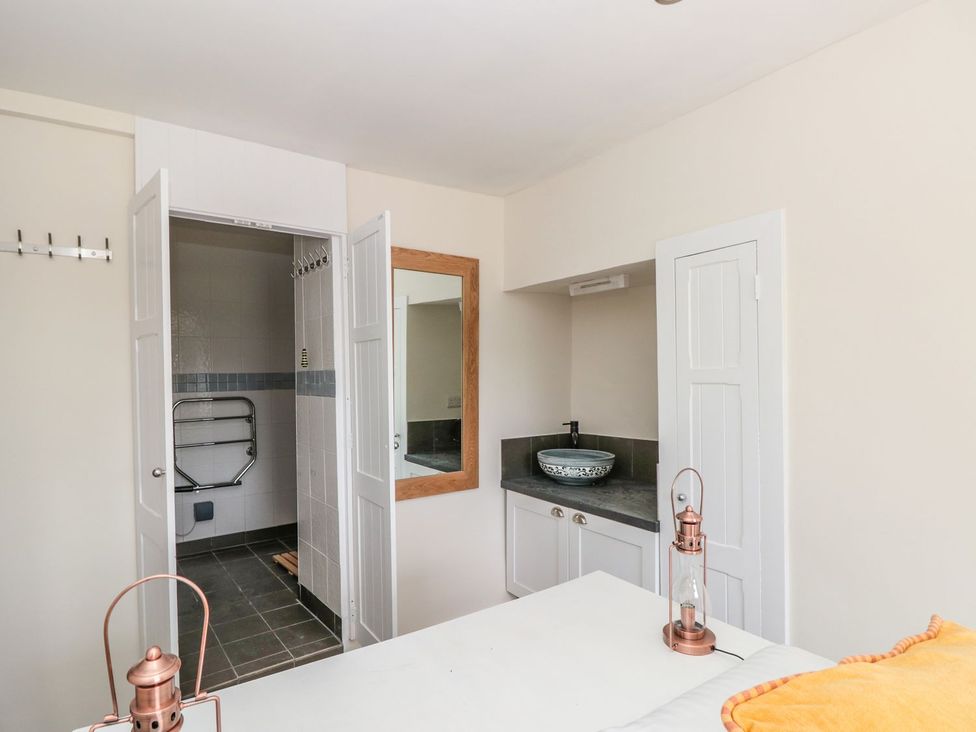 A bathroom with a sink and mirror at Ty'r Ddraig in Dartmouth