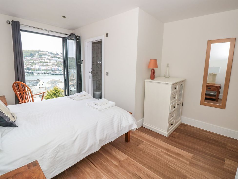 A bedroom with a bed and dresser at Ty'r Ddraig in Dartmouth