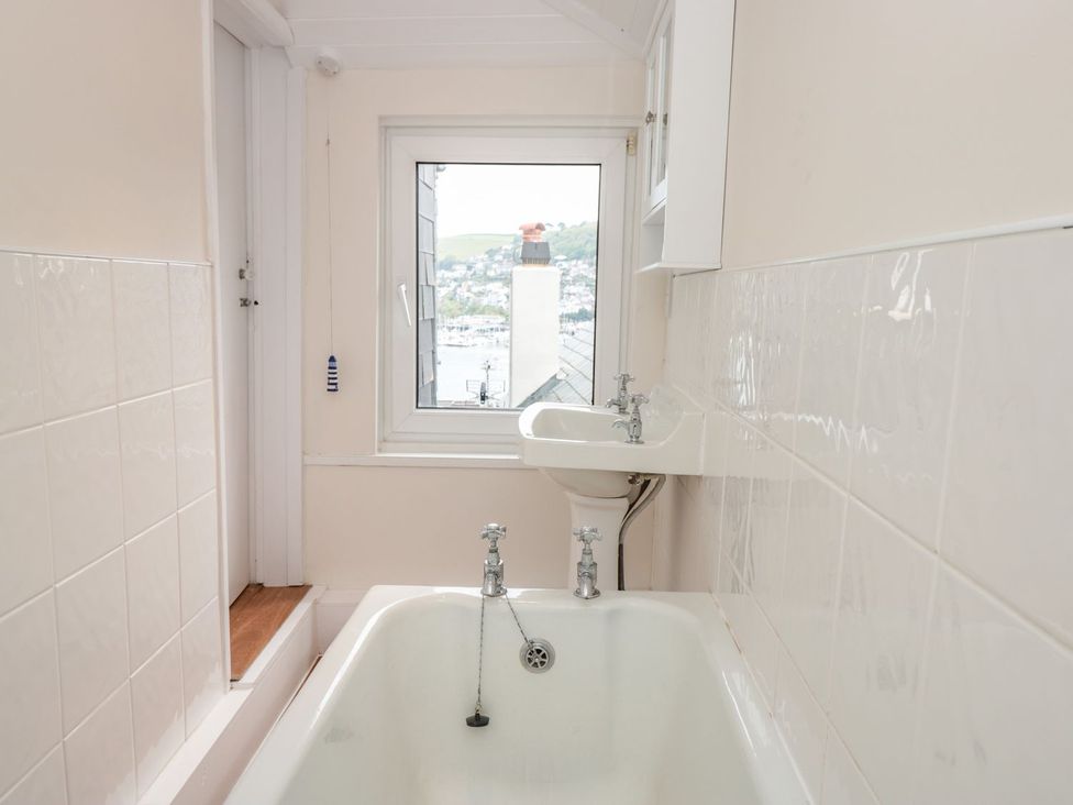 A bathroom with a bathtub and sink at Ty'r Ddraig in Dartmouth