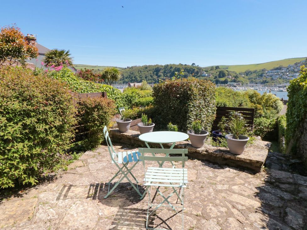 A garden space with a table and chairs at Ty'r Ddraig in Dartmouth