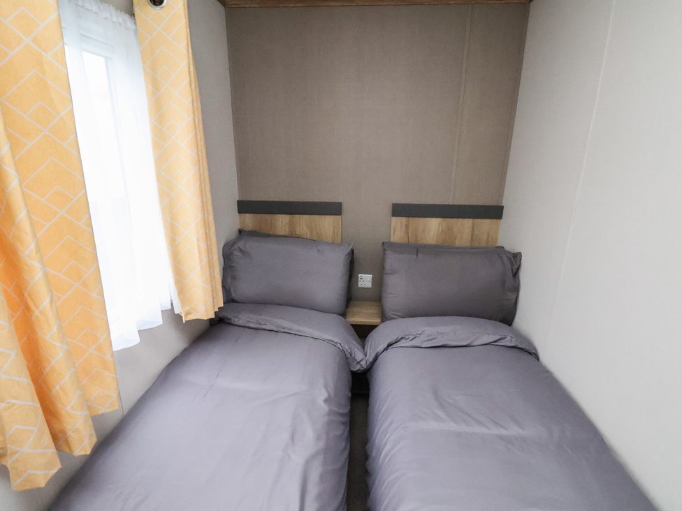 A bedroom with twin beds and curtains at No. 7 Ivy, Scarborough