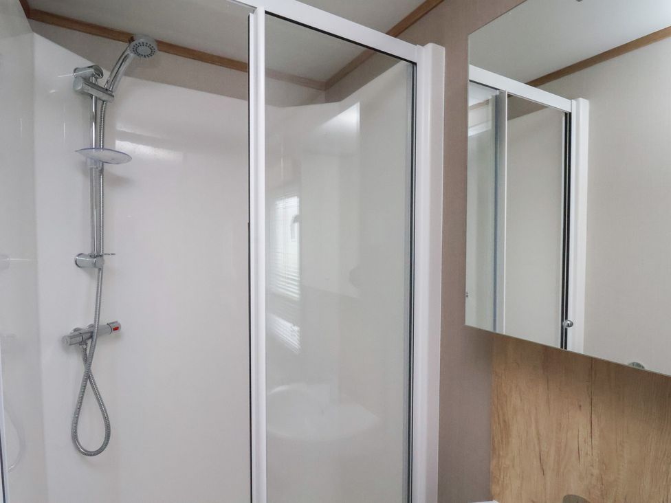 A bathroom with a shower and mirror at No. 7 Ivy Scarborough