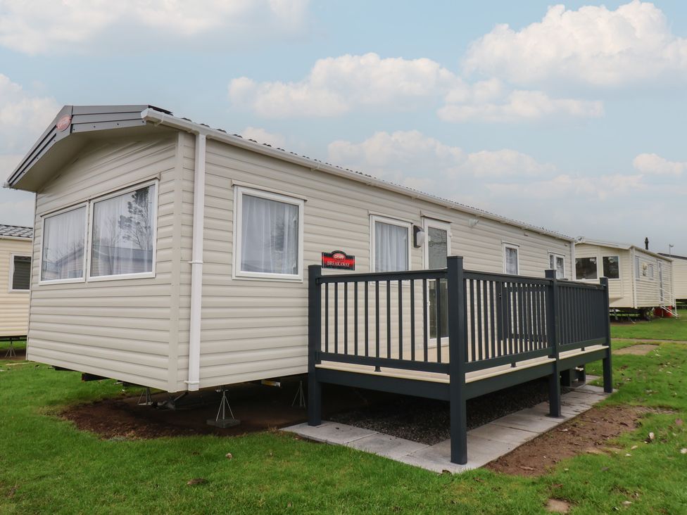A mobile home with a deck and railings at No. 7 Ivy in Scarborough