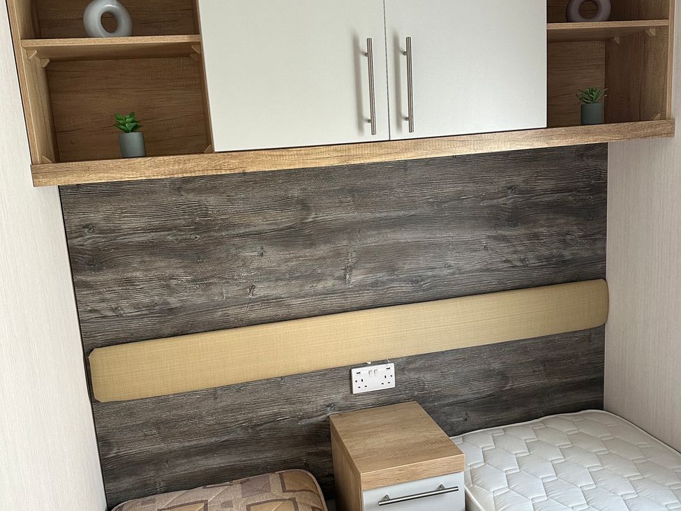 A bedroom with a bed and nightstand at TW89 in Exmouth