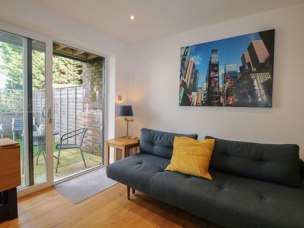 A living room with a sofa and sliding door to patio at No 1 The Crickets Bognor Regis