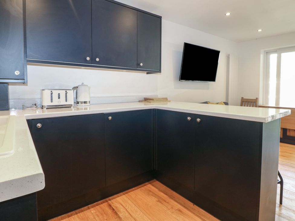 A kitchen with black cabinets and appliances at No 1 The Crickets in Bognor Regis