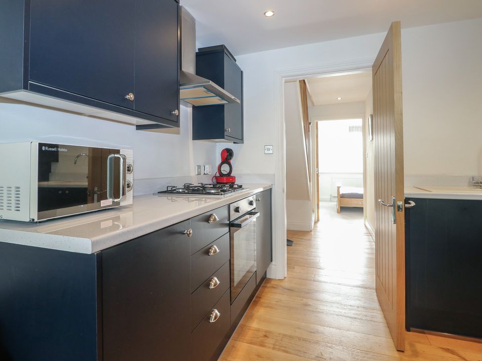 A kitchen with a microwave and cooker at No 1 The Crickets in Bognor Regis