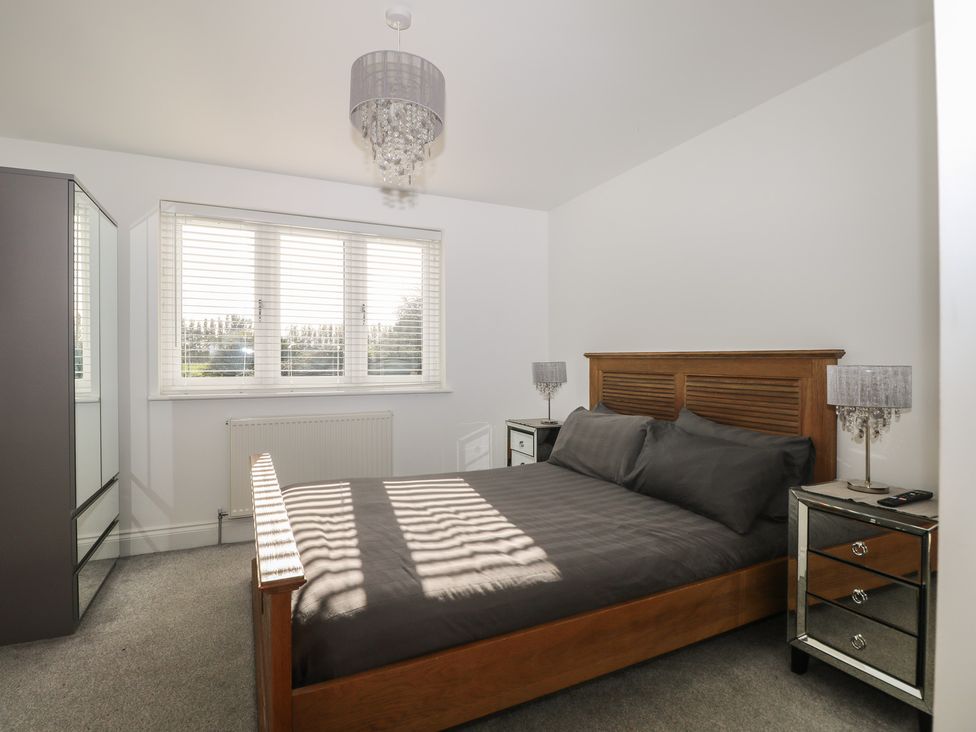 A bedroom with a bed and wardrobe at No 1 The Crickets in Bognor Regis