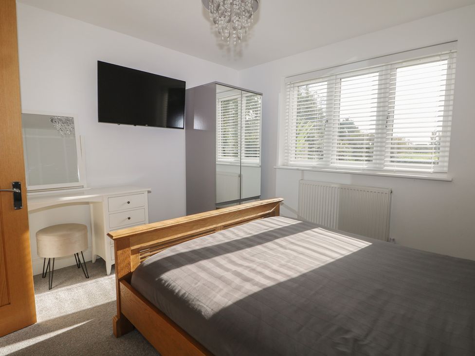 A bedroom with a bed, television, wardrobe, and mirror at No 1 The Crickets Bognor Regis