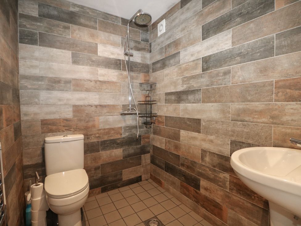 A bathroom with a toilet, shower, and sink at No 1 The Crickets in Bognor Regis