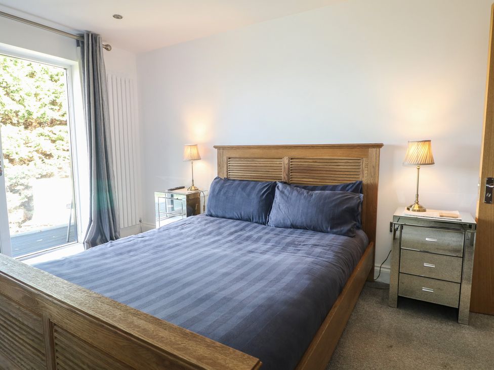 A bedroom with a bed and nightstand at No 1 The Crickets in Bognor Regis