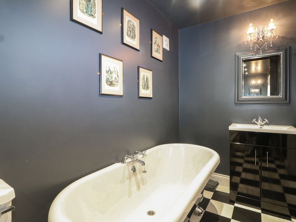 A bathroom featuring a bathtub, sink and wall art at No 1 The Crickets in Bognor Regis