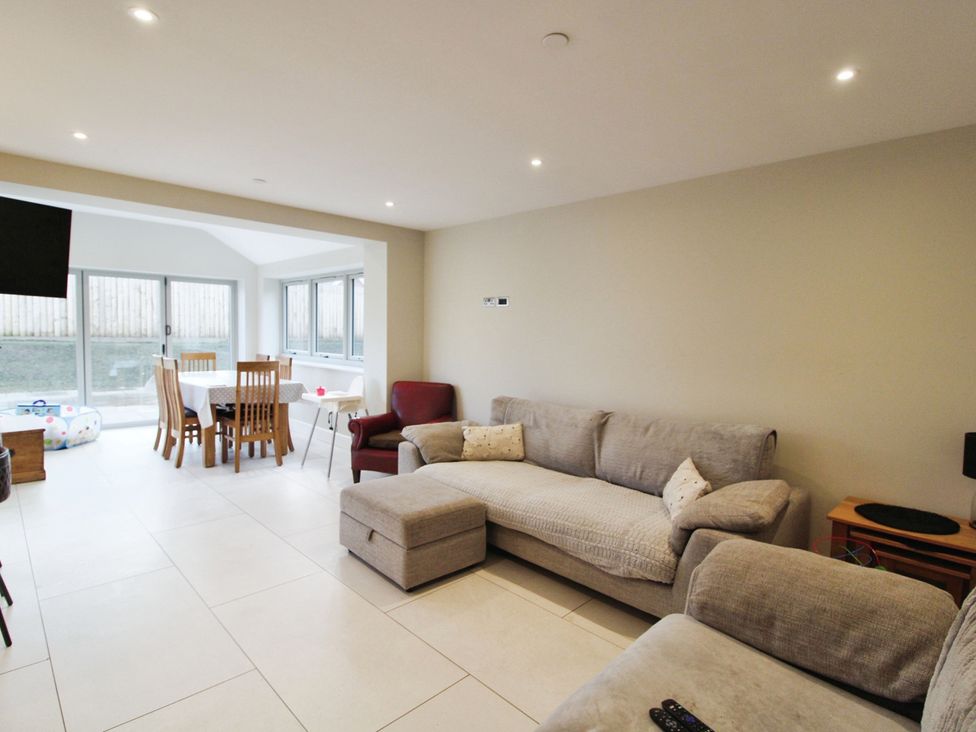 A living room with a sofa and dining area at Cefn Coed in Presteigne