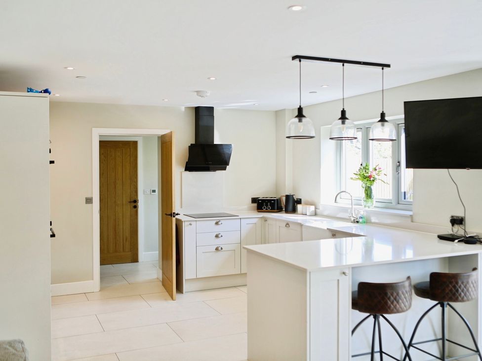 A kitchen with a counter, sink, and cooking area at Cefn Coed in Presteigne