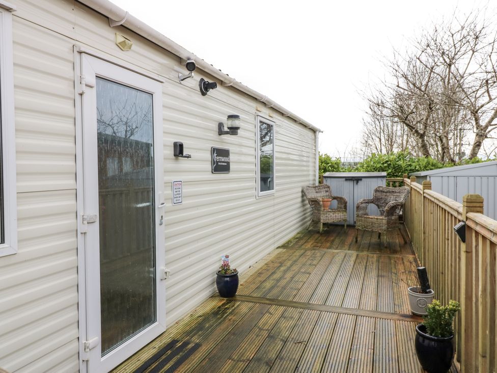 An outdoor deck area with chairs and plants at Plot 42 in Carlisle
