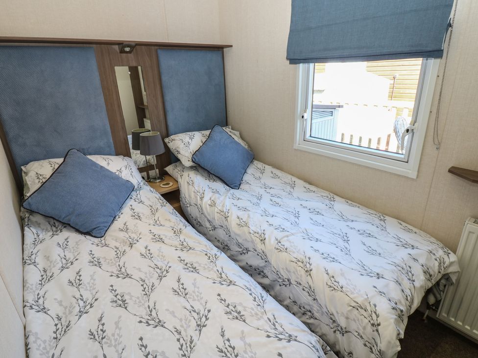 A bedroom with two single beds and a window at Plot 42 in Armathwaite