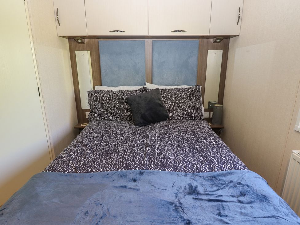A bedroom with a bed and bedside table at Plot 42 in Armathwaite