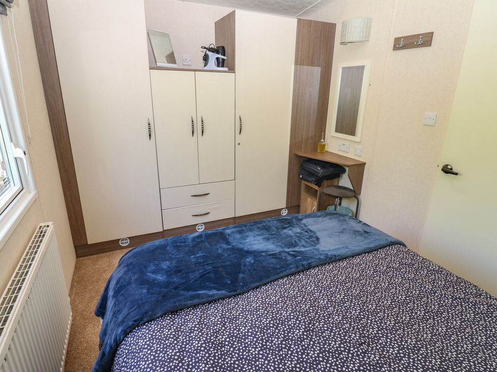 A bedroom with a bed and wardrobe at Plot 42 in Armathwaite