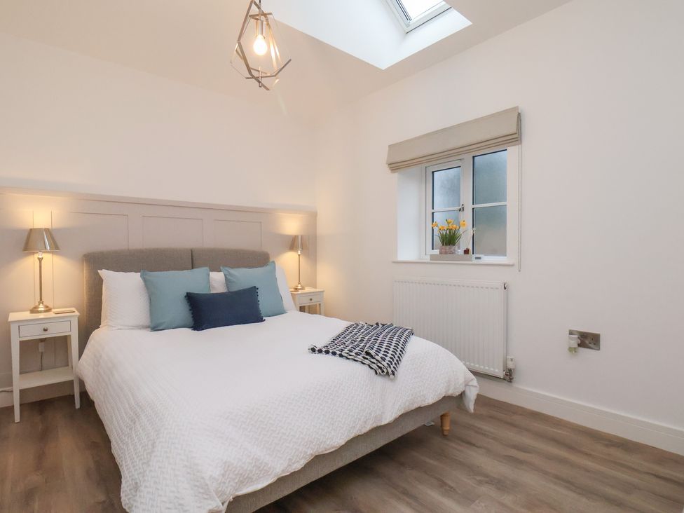 A bedroom with a bed and bedside tables at The Nest in Buckton near Bridlington