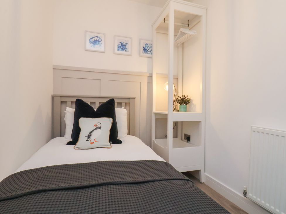 A bedroom with a bed and wardrobe at The Nest in Buckton near Bridlington