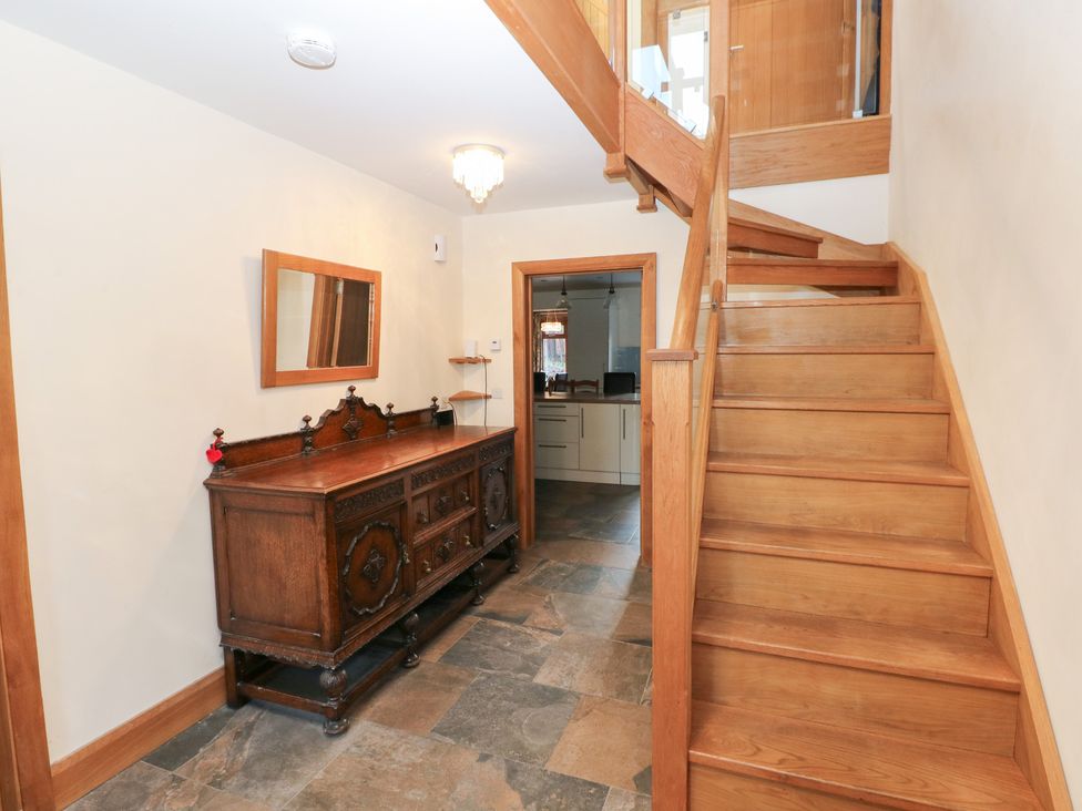 A hallway with a console table and stairs at Ty-Gan Dderwen Llanelli