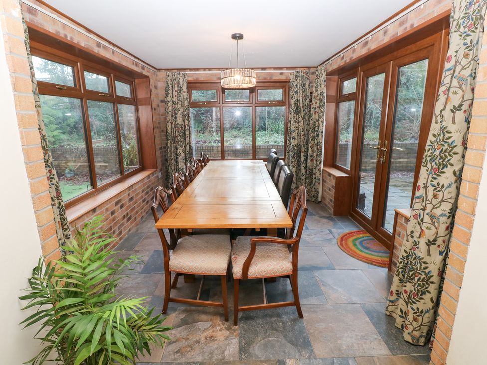 A dining room with a wooden table and chairs at Ty-Gan Dderwen in Llanelli