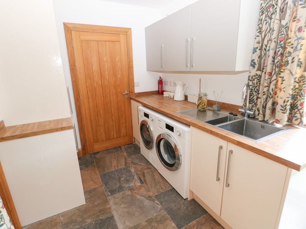 A laundry room with a washer and dryer at Ty-Gan Dderwen in Llanelli