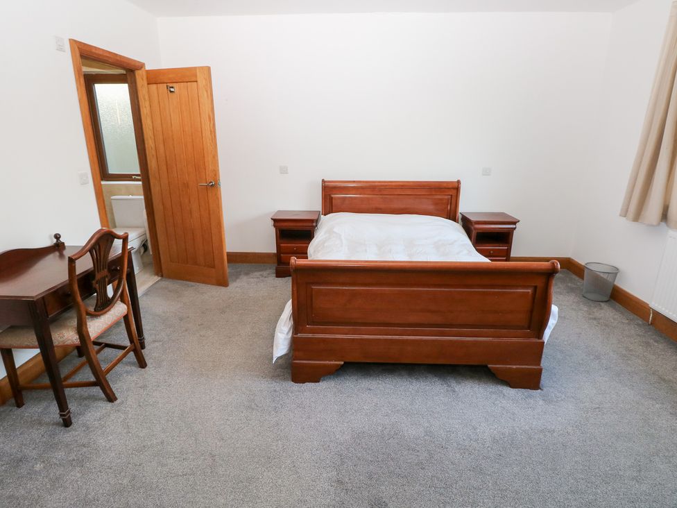 A bedroom with a bed and desk at Ty-Gan Dderwen in Llanelli
