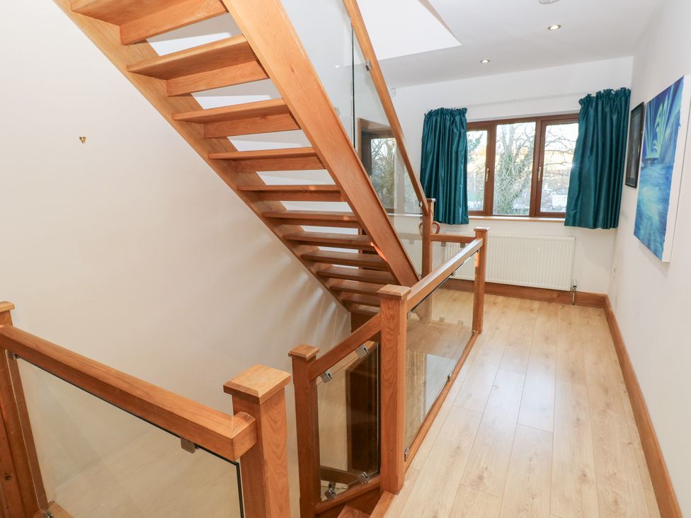 A hallway with a staircase and windows at Ty-Gan Dderwen in Llanelli