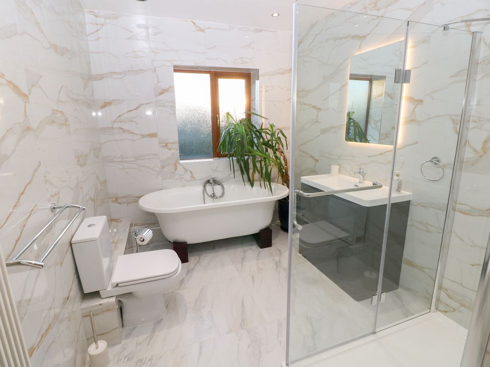 A bathroom with a bath tub and shower at Ty-Gan Dderwen in Llanelli